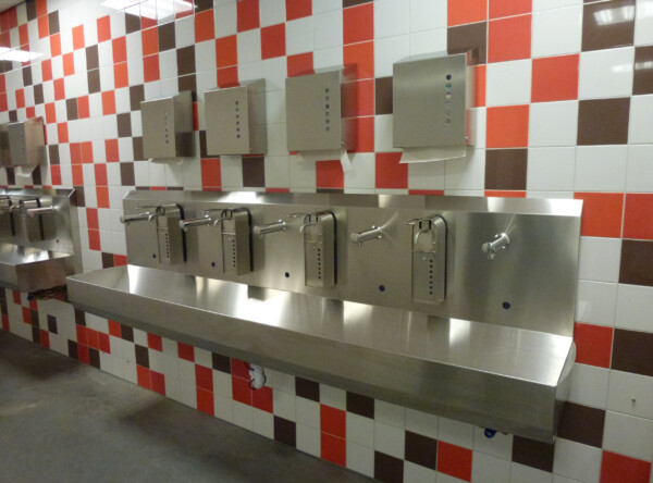 RVS handwasbak 5 persoons sensorbediend met zeepdispensers en vouwdoekdispensers erboven
